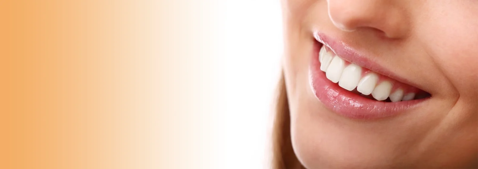 Close-up of a smiling person with bright white teeth, emphasizing oral health, against an orange gradient background.
